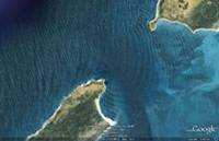 aerial view of ocean waves diffracting around a headland
